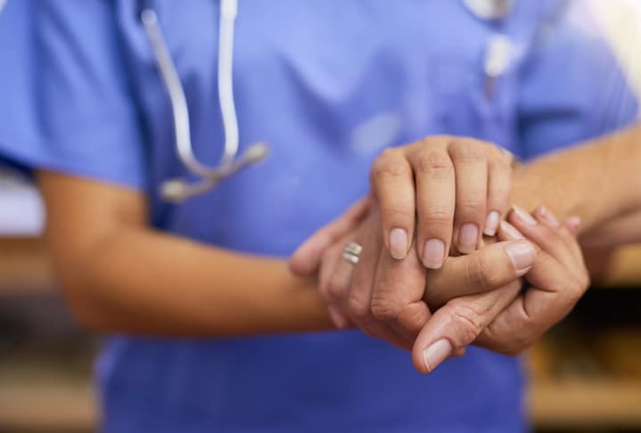 Cropped shot of a nurse holding a senior woman's hands in comfort