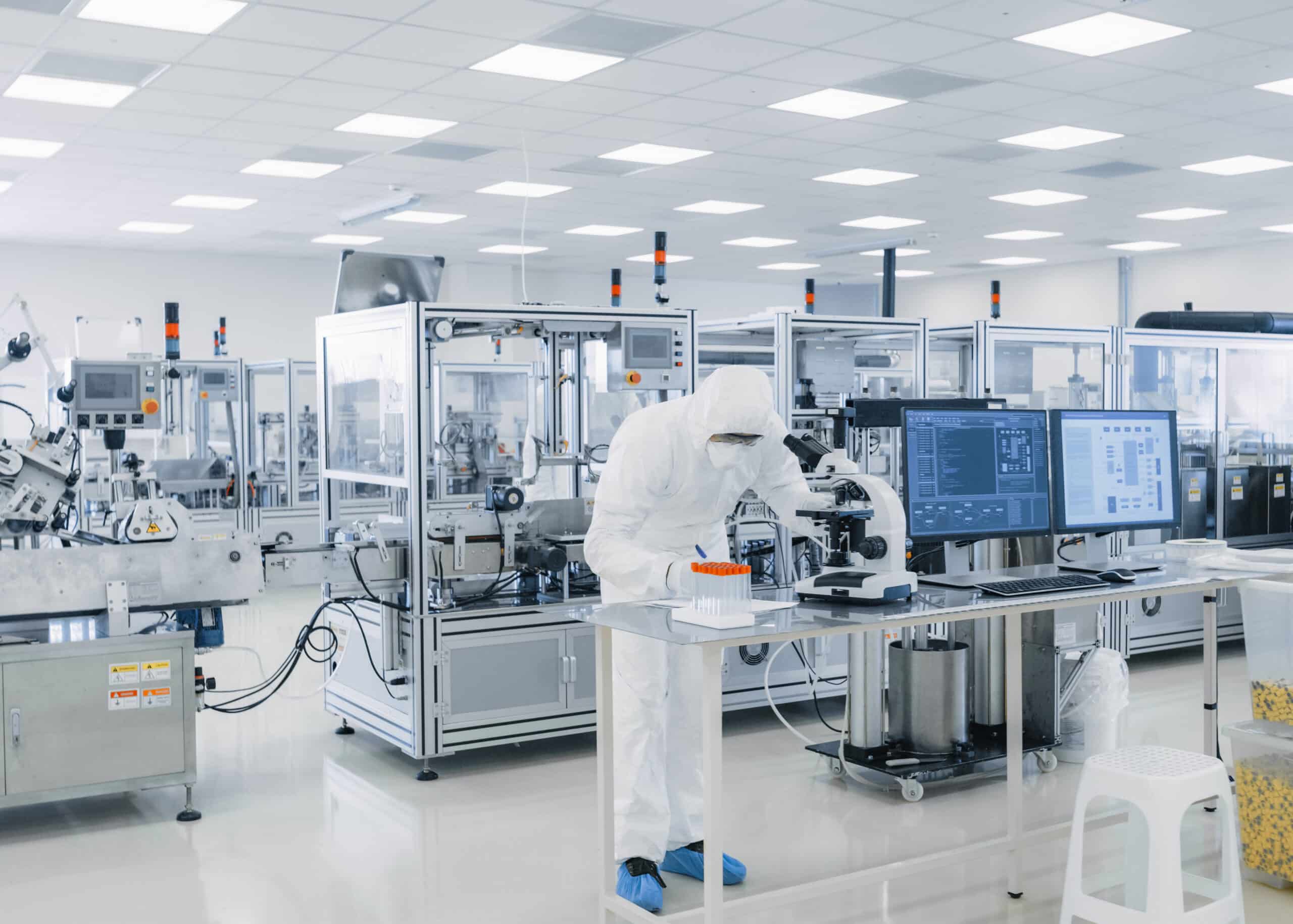 A lab worker in a manufacturer room writing down notes