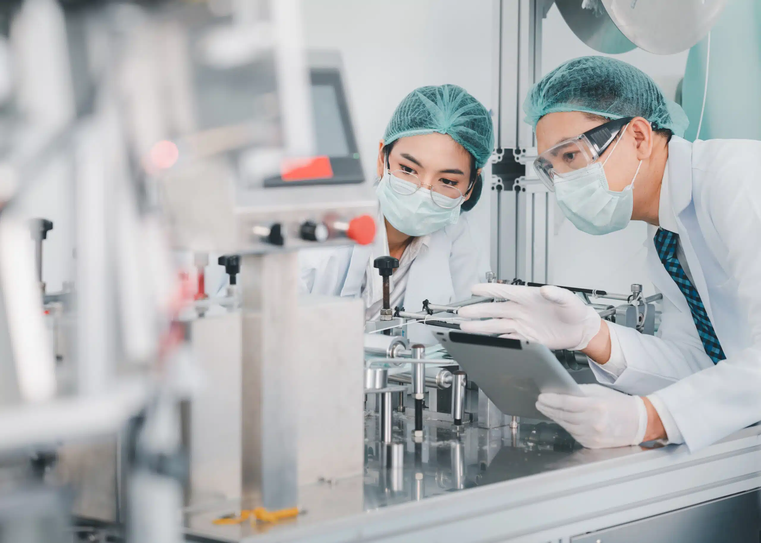 Two lab workers checking on site for deviation accuracy while holding a tablet