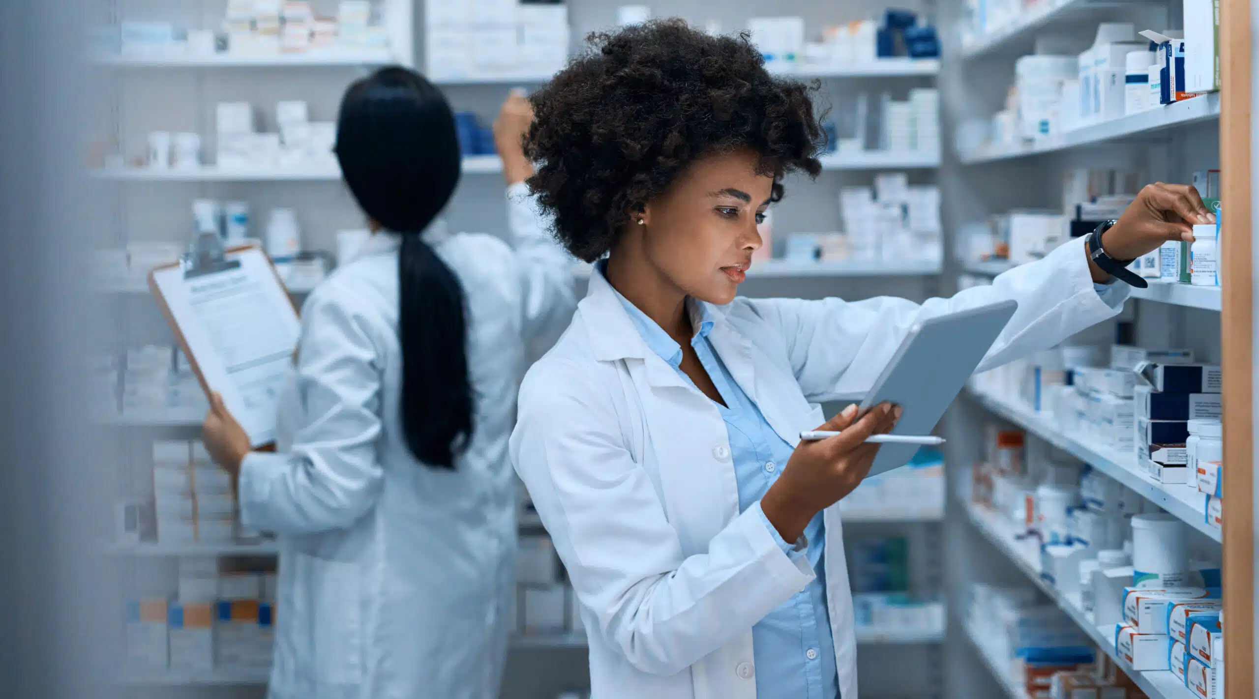 A worker in a lab coat logging stock of product