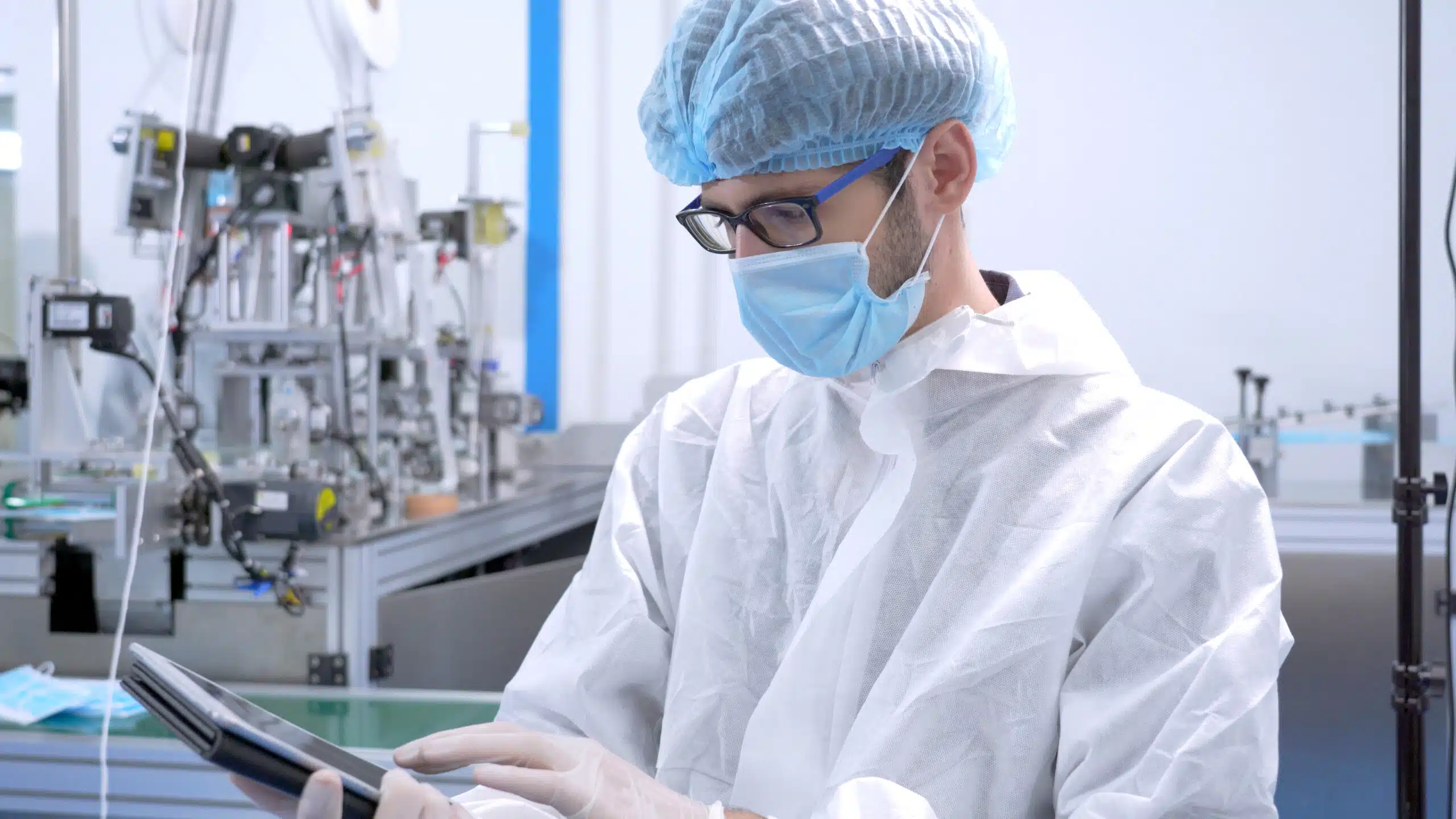 Man in personal protective equipment logging a nonconformance on his digital quality management system on site using a tablet