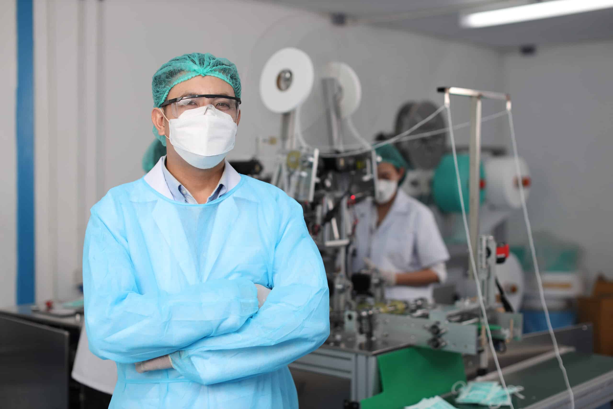 A man facing the camera and smiling on site for a medical device production facility