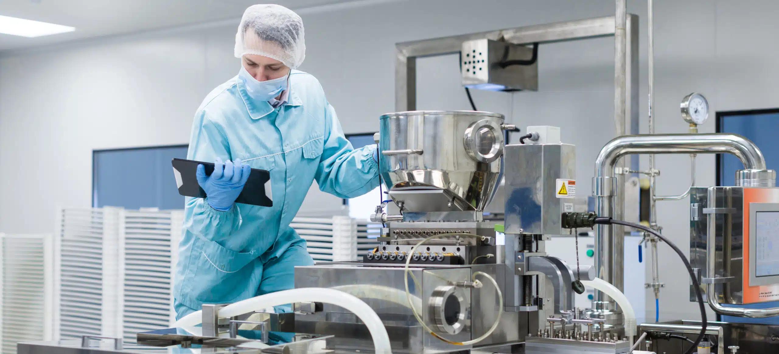 A man next to production machinery using a tablet to investigate OOS tracking while on site